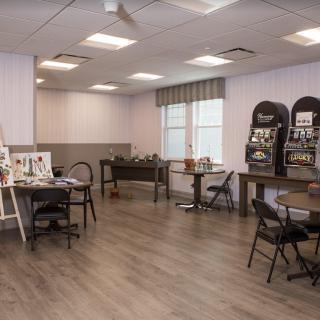 A versatile room featuring tables, chairs, a foosball table, and magazine racks.
