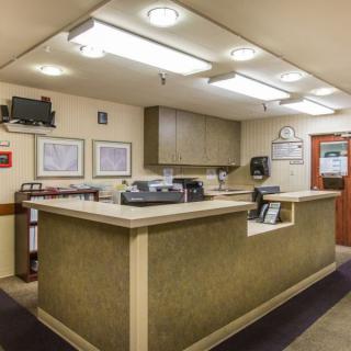 A neatly organized reception desk in an office setting with overhead lighting.