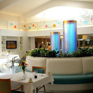 A modern restaurant interior featuring decorative lighting and colorful columns.