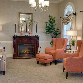 A cozy living room with a classic fireplace, elegant armchairs, and traditional decor.