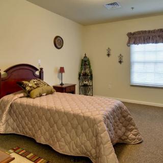 A simple bedroom with a single bed and minimalistic decor.