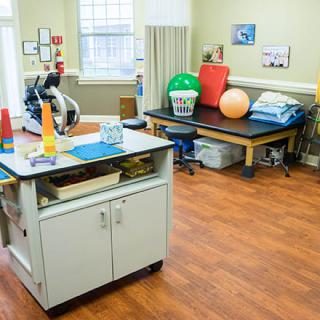 A well-equipped physical therapy room with exercise tools and a treatment bed.