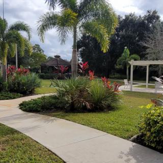 A beautifully landscaped garden with a winding pathway and vibrant tropical plants.