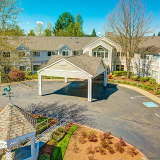 Aerial view of a residential building with landscaped gardens and a driveway.