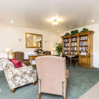 A cozy living room with a seating area and a large bookshelf.