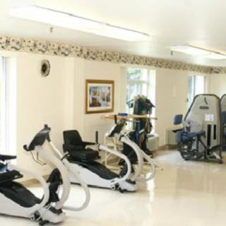 A well-lit gym room featuring various exercise machines.