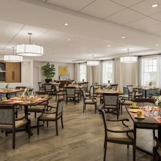 A spacious and elegantly designed dining room featuring well-arranged tables and chic lighting.