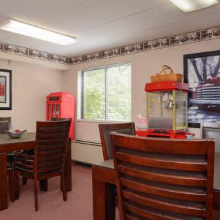 An office space with wooden furniture, a popcorn machine, and decorative artwork on the walls.
