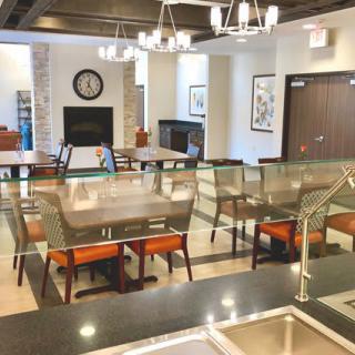 A modern and spacious dining area with stylish seating and elegant chandeliers.