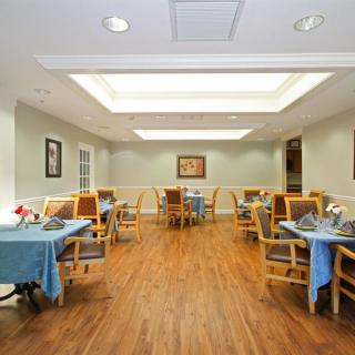 A well-lit dining area with neatly arranged tables and chairs.