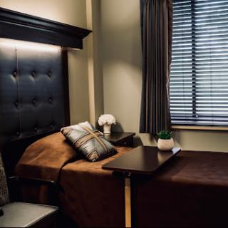 A serene and cozy bedroom setting featuring a neatly made bed, stylish decor, and soft lighting.