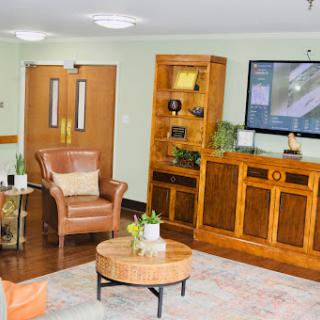 A cozy living room setup featuring comfortable seating, elegant wooden furniture, and a television.