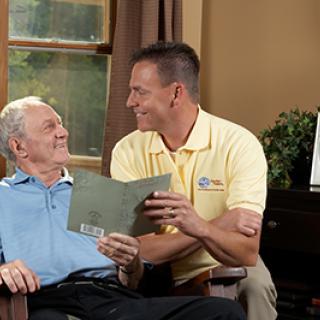 A warm moment shared between an elderly man and his caregiver, showcasing companionship and care.