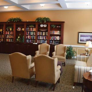 A cozy library room featuring comfortable armchairs and well-stocked bookshelves.