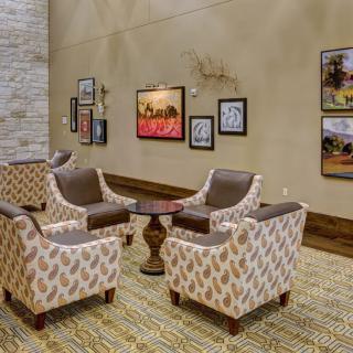 A cozy lobby seating area featuring patterned chairs and wall art.