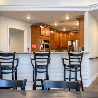 A modern kitchen with wooden cabinets and bar seating.