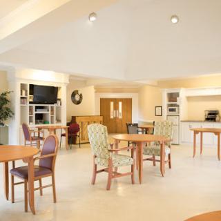 A spacious and well-lit dining area featuring modern furniture and a welcoming atmosphere.