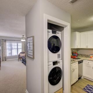 Modern apartment interior with a stackable washer and dryer beside the kitchen.