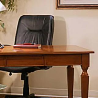 A tidy workspace featuring a wooden desk and a black office chair.