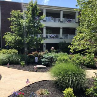 A well-maintained garden with a walkway leading to a multi-level building.