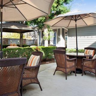 A cozy outdoor patio with wicker furniture and umbrellas, perfect for relaxation.