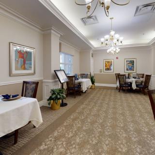 A well-decorated dining area with elegant chandeliers and art on the walls.