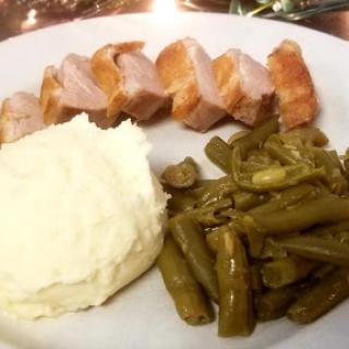 A delicious plate featuring grilled chicken, creamy mashed potatoes, and sauted green beans.