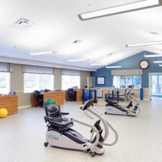 A spacious gym with exercise equipment, designed for fitness and rehabilitation.