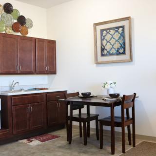 A cozy kitchen and dining space with wooden cabinets and a small dining table set.