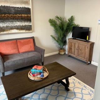 A cozy living room with a sofa, coffee table, and TV.