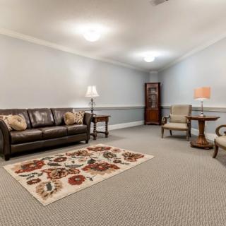 A cozy living room with a sofa, chairs, and a colorful carpet.