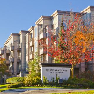 A modern apartment building surrounded by autumn foliage.