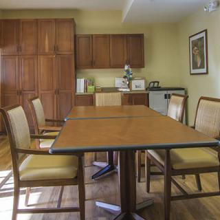 A small conference room with a meeting table and chairs, surrounded by wooden cabinetry.