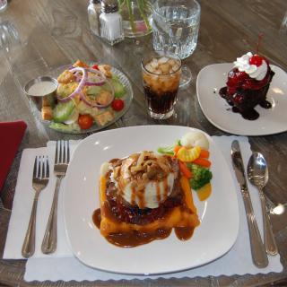 A table set with a main course, salad, dessert, and a beverage.