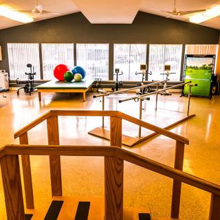 A rehabilitation center equipped with exercise equipment and therapy balls for physical therapy sessions.