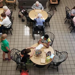 People sitting and socializing at tables in a cafe setting.