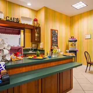 A cozy cafe interior with a counter displaying various food items and coffee cups.
