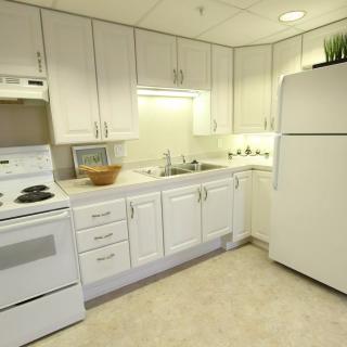A clean, modern kitchen with white cabinets and standard appliances.
