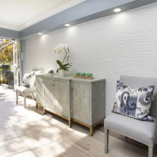 A modern living space with natural light, featuring a sideboard and stylish chairs.