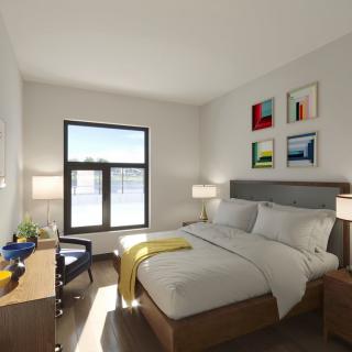 A modern bedroom with neutral tones and colorful artwork on the wall.