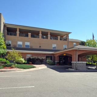 A view of a modern building with a covered entrance and landscaped surroundings.