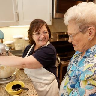 Two women enjoying a baking session together in a kitchen.
