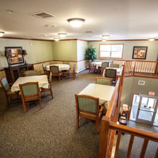 A spacious dining area designed for communal meals, featuring tables and chairs arranged for comfort.