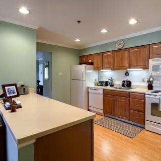 A modern kitchen with wooden cabinets and stainless steel appliances.