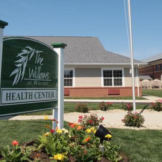 A health center with a green sign and landscaped garden.