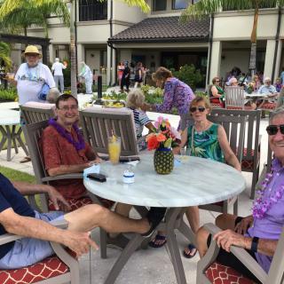A group of friends relaxing by the pool in a tropical setting.