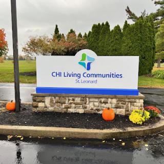 Entrance sign for CII Living Communities, decorated with autumn elements.