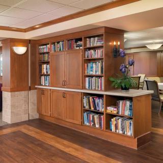 A cozy library corner with a wooden bookshelf filled with books.
