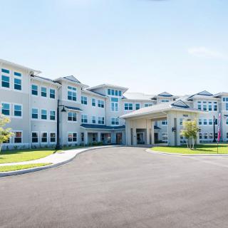 A modern multi-story building with numerous windows and a welcoming entrance.
