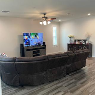 A cozy living room featuring a modern sofa arrangement and a wall-mounted television.